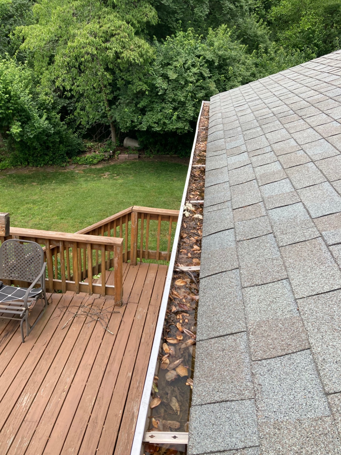 Before gutter cleaning with leaves and debris packed in the channel